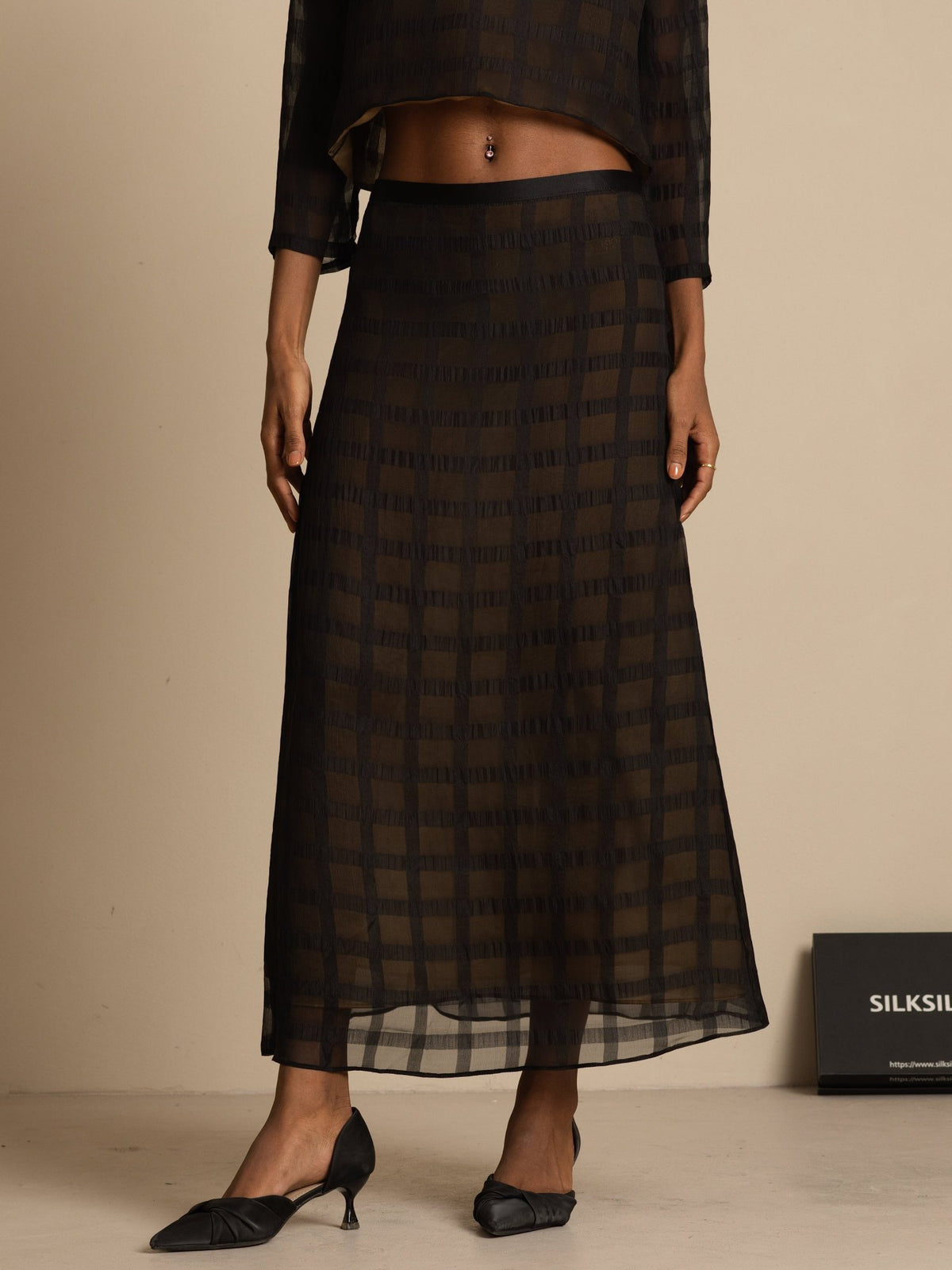 Black silk high-waist A-line midi skirt with textured grid pattern