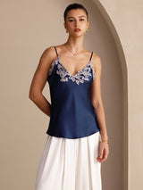 [Dark Blue] Navy blue camisole with slim straps and pale floral-lace V-neck, waist-up front view, both hands held behind the back. 004