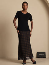Model wearing a black pure silk high-waist A-line grid long skirt with sheer texture
