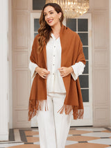 [Brown] warm brown rectangular shawl with fringed edges, styled front view, draped over the shoulders with hand holding an edge. 003