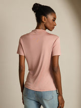 [Pink] Rear studio view of a model wearing a blush-pink short-sleeve crew-neck top with light blue jeans. 002