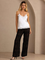 [White] White lace-trim V-neck camisole top on a model in a full-body front view with arms relaxed and feet close together. 007
