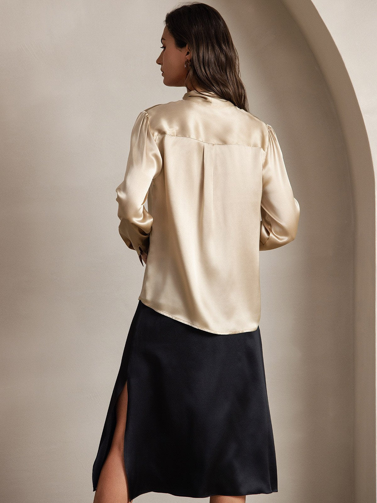 [Champagne] Full-length back view of a 19 momme silk long-sleeve blouse with a large tie-neck bow in champagne beige 002