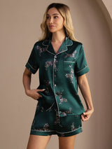 [Emerald Zebra] Angled front view of a silk short-sleeve pajama set with shorts in emerald green with small light animal motifs 003