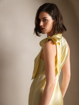 [Light Yellow] Rear studio view of a model wearing a pale yellow sleeveless maxi dress with a tied scarf neckline. 002