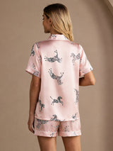[Pink Zebra] Full back view of a silk short-sleeve pajama set with shorts in pale pink with small dark animal motifs 002