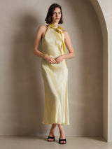 [Light Yellow] Full-length front view of a pale yellow scarf-neck maxi dress, with both hands joined at the waist. 003