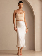[Beige] Three-quarter full-body front studio view of a model wearing cream glossy maxi skirt. 007