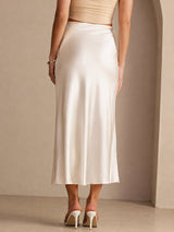 [Beige] Lower-body back studio view of a model wearing cream glossy maxi skirt, showing the long skirt shape. 002