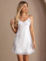 [White] Front view of a white lace-trim mini slip dress, with one hand raised near the hair. 005