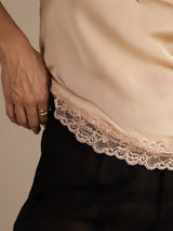 [Champagne] Champagne lace-trim V-neck camisole top in a lower close-up showing scalloped lace and nearby fabric. 005
