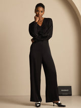 [Black] A straight front view shows black wide-leg trousers with a black blouse, distinguished by one hand held at the waist. 007