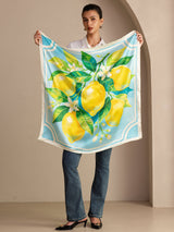 [Blue Lemon] Held-open view of a 90 cm silk scarf in aqua blue and white with yellow lemons, green leaves, and a pale border 006