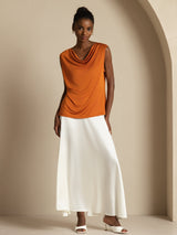 [Orange] Head-to-toe stance: orange sleeveless cowl-neck top with a white maxi skirt, with weight held on one leg. 006
