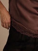 [Brown] Brown lace-trim V-neck camisole top in a lower close-up showing scalloped lace and nearby fabric. 005