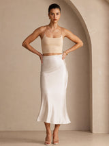 [Beige] Cream glossy maxi skirt on a model in a full-body front view with both hands at her waist and feet apart. 006