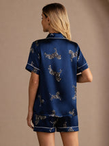 [Navy Zebra] Full back view of a silk short-sleeve pajama set with shorts in navy blue with small light animal motifs 002