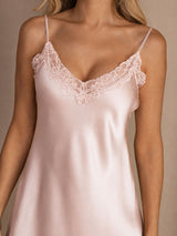 [Pink] Close studio view of a model wearing a pale pink spaghetti-strap mini slip nightdress with lace trim. 004
