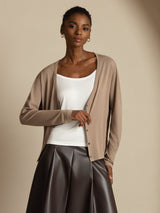 [Tan] Front waist-up view: beige cardigan, white camisole, and dark brown maxi skirt, with both arms lowered. 004