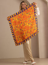 [Orange Dog] Held-open front view of a 90 cm square silk scarf in orange, yellow, and red animal print with a dark striped border 004