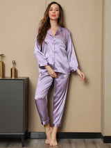 [Lavender] lavender purple long-sleeve buttoned pajama set with piping, full front view, model leaning lightly against the wall. 003