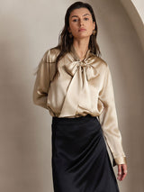 [Champagne] Waist-up front view of a 19 momme silk long-sleeve blouse with a large tie-neck bow in champagne beige 003