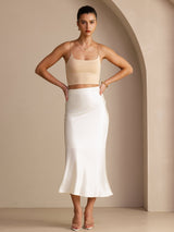 [Ivory] Ivory glossy maxi skirt on a model in a full-body front view with both hands at her waist and feet apart. 005