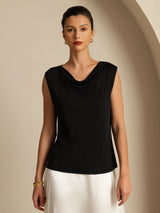 [Black] A front three-quarter crop centers black cowl-neck top with a white maxi skirt; the model bends one arm along the side. 001