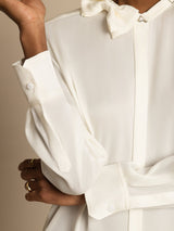 [White] Close studio view of a model wearing a white long-sleeve collared blouse with black wide-leg trousers. 005