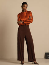 [Bitter Chocolate] Full-length view: brown high-rise wide-leg trousers with a rust-orange blouse, with weight shifted to one leg. 006