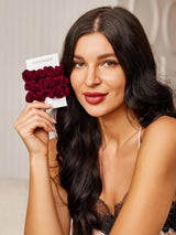 [Fuchsia] Woman holding three burgundy mulberry silk scrunchies on SilkSilky card 002