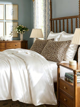 White mulberry silk pillowcase on bed with leopard print pillows in elegant bedroom
