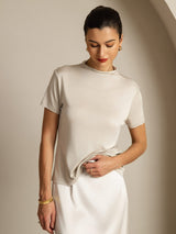 [Gray] Straight waist-up view: light gray short-sleeve crew-neck top with a white skirt, with both arms down. 005