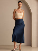 [Dark Blue] Three-quarter full-body front studio view of a model wearing navy blue glossy maxi skirt. 006
