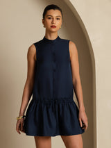 [Dark Blue] Navy sleeveless drop-waist mini dress with a gathered ruffle hem in a front view cropped at the upper thighs, arms down. 004