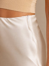 [Beige] Cream glossy maxi skirt on a model in a tight waist crop showing the smooth waistband and diagonal sheen. 004