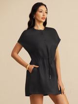 [Black] black cap-sleeve short dress with drawstring waist and pockets, waist-up view, model standing with one hand in a pocket. 001