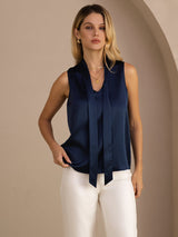 [Dark Blue] Navy blue sleeveless tie-neck top on a model in a full-body front view with one hand at her hip and weight shifted. 003