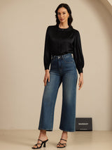 [Black] Black round-neck lantern-sleeve blouse on a model in a full-body front view with one hand at her hip and weight shifted. 006
