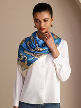 [Blue Fish] Close styled view of a 90 cm square silk scarf in bright blue with multicolor fish motifs and a pale patterned border 004