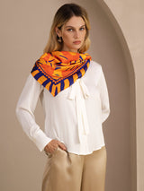 [Orange Dog] Orange, yellow and red animal-print square scarf with dark striped border, styled front, draped at neck, hand in pocket. 005
