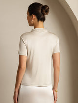 [Gray] Rear studio view of a model wearing a light gray short-sleeve crew-neck top with a white skirt. 002