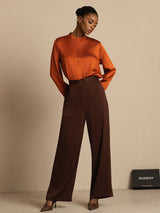[Bitter Chocolate] Brown wide-leg trousers with a rust-orange blouse appears in a frontal pose with one hand touching the waistline. 007