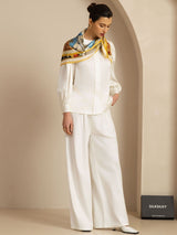 [P107] Multicolor print scarf with a gold border in a front view to knees, scarf over the shoulders, one hand in a pocket. 004