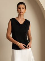 [Black] Three-quarter view: black sleeveless cowl-neck top with a white maxi skirt, with the body turned. 003