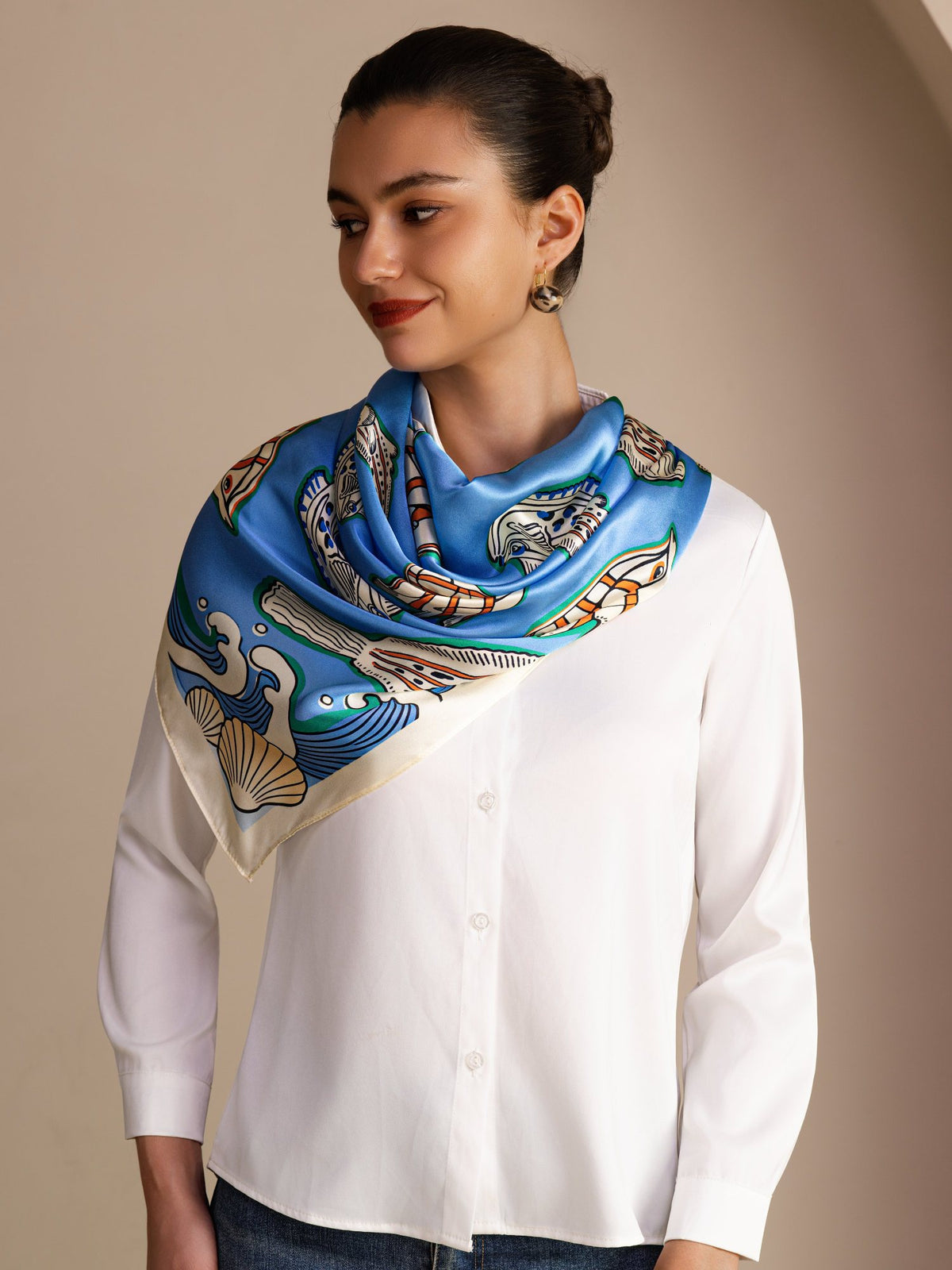 [Blue Fish] Bright blue square scarf with multicolor fish and pale patterned border, styled front, tied at neck, point on chest. 002