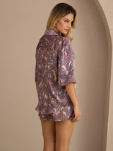 [Pink Palm] Rear studio view of a model wearing a mauve short pajama set with a multicolor palm-leaf print. 002