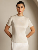 [Gray] A mid-length frontal view shows light gray crew-neck top with a white skirt, with one arm bent at the model's side. 001