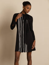 [Black] Black long-sleeve tunic mini dress with vertical white stripes in a front crop to thighs, one hand held near the collar. 004