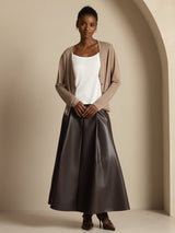 [Tan] Head-to-toe view: beige button-front cardigan, white camisole, and dark brown maxi skirt, with one leg set ahead. 008